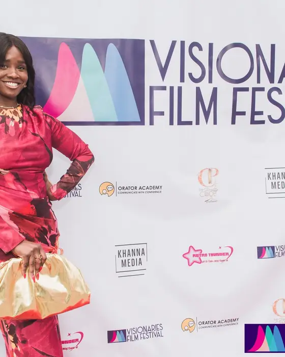 A guest posing in front of the festival wall