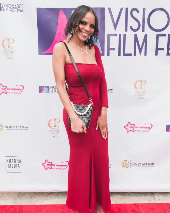 A guest in red on the red carpet